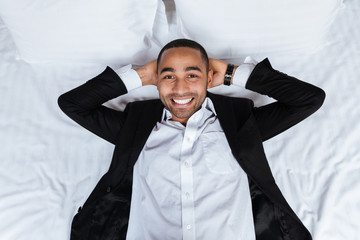 Top view of African man lying on bed