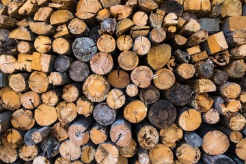 Chopped firewood, stacked woodfuel, fuelwood texture. Natural wooden background.