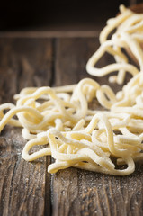 Italian homemade uncooked pasta on the wooden table