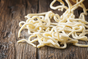 Italian homemade uncooked pasta on the wooden table