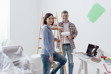 Couple painting their house - obrazy, fototapety, plakaty