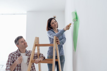 Couple painting walls together
