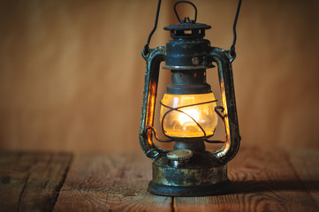 vintage kerosene oil lantern lamp burning with a soft glow light - 132678880