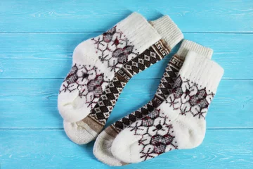 Selbstklebende Fototapeten Wool socks on a wooden blue background.   © besklubova