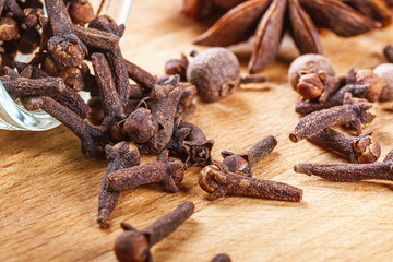 cloves, allspice, star anise on a wooden board closeup