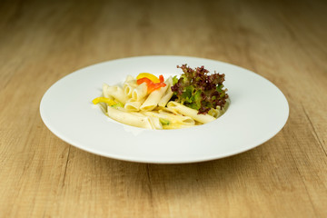 Delicious pasta on plate on wooden table