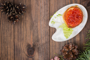 healthy appetizer : sandwich with red caviar on white china plate. Wooden background. Top view. Close-up