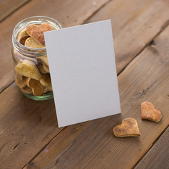 Empty card against a jar of heart-shaped cookies.