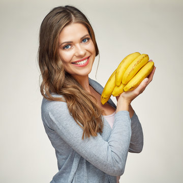 smiling woman with long hair holding banana.