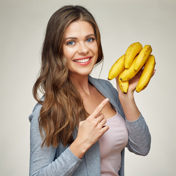 smiling woman pointing finger on banana .