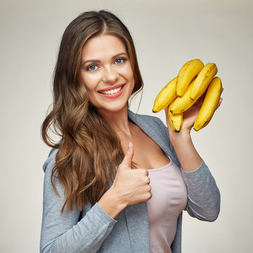 smiling woman holding banana show thumb up.