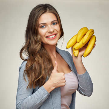smiling woman holding banana show thumb up.