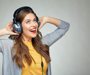 happy dancing woman with headphones isolated on gray background