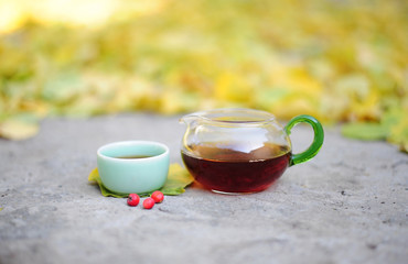 Glass tea pot and ceramic cup with red tea for Chinese tea ceremony