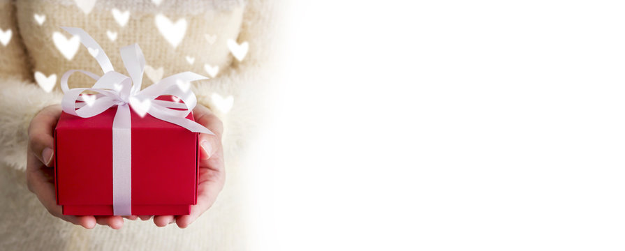 Valentines day concept of young woman hands holding red gift box