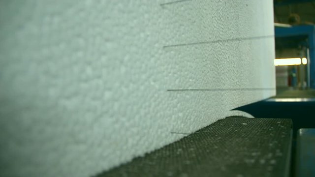 Production of polystyrene, styrofoam in a factory. Cutting of styrofoam with wires.