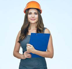 Smiling business woman with clipboard wearing protect helmet.