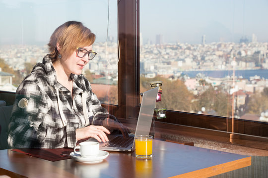 Cute female Freelancer working on Computer at Roof top Cafe