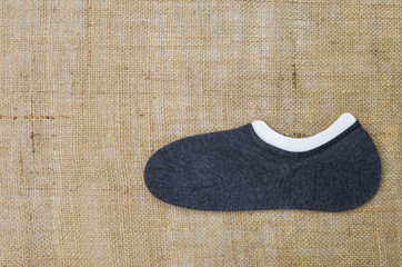 Grey sock on hessian background