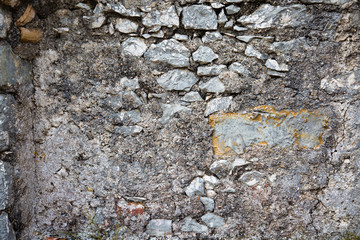 Surface of old stone wall of a medieval fortress. Closeup natural background.  Rough outdoor stone wall texture.