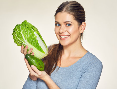 Beautiful young woman studio portrait with cabbage and avocado.