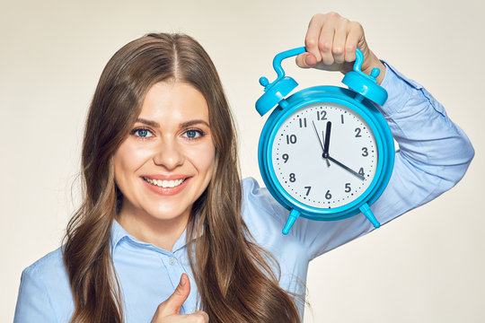 close up face portrait of smiling woman holding alarm clock .