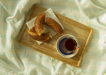 Breakfast in bed, Bagel and cup of turkish tea on the wood tray
