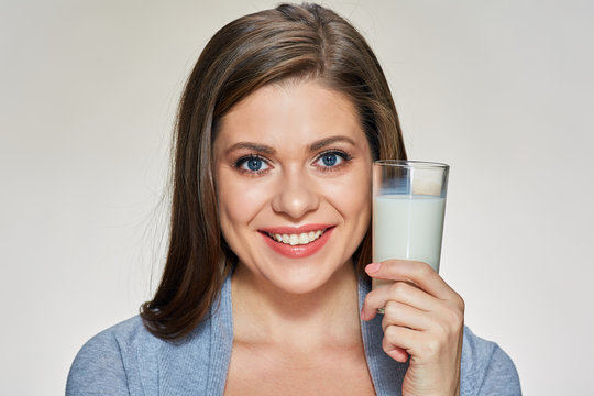 Smiling woman holding milk glass.