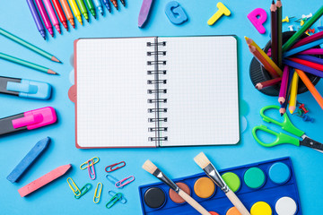 Overhead shot of school supplies on blue background