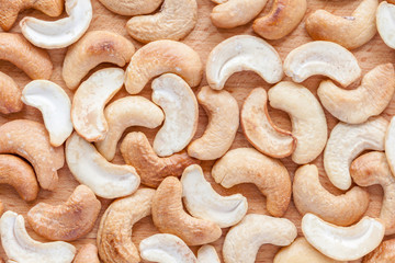 Roasted cashew nuts texture on wooden background.