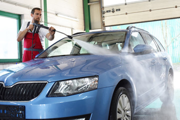 Kundendienst: Fahrzeugpflege im Autohaus durch Arbeiter - Autowäsche