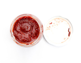 Jar with tomato paste , top view on white.