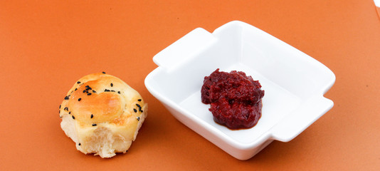 Tomato paste in small white dish. On white.
