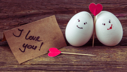 .The love of two eggs, red hearts and card with text I love you