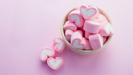 Obraz na płótnie Canvas Pink heart-shaped marshmallows in with pink background
