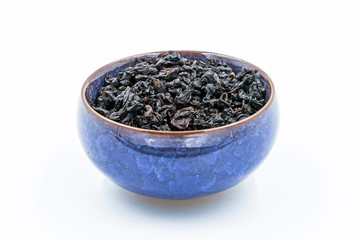 Chinese Oolong Dark Red tea (Black Tie Guan Yin) in a blue ceramic bowl