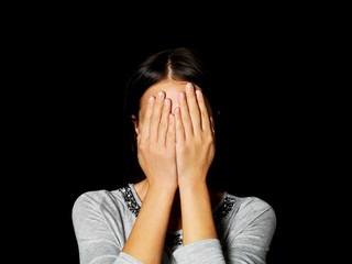 Young woman covering her face with her hands