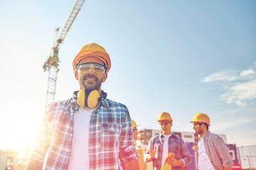 group of smiling builders in hardhats outdoors