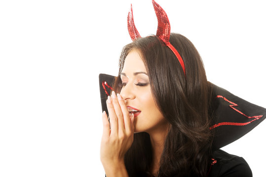Portrait of woman wearing devil clothes whispering to someone