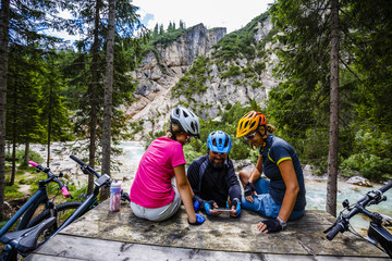 Family bike rides in the mountains while relaxing on the bench c