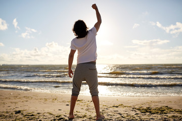 man with rised fist on beach