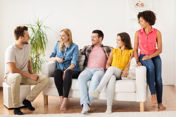 group of happy friends talking at home