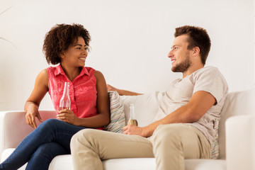 happy friends or couple with beer talking at home