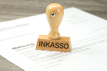 Eine Mahnung und ein Stempel mit dem Aufdruck Inkasso
