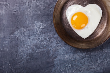 Fried egg in heart shape on the pan.Holiday Valentine's Day.Breakfast. Healthy Food.selective focus.