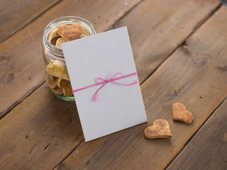 Empty card against a jar of heart-shaped cookies.
