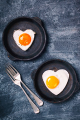 Fried egg in heart shape on the pan.Holiday Valentine's Day.Breakfast. Healthy Food.Toned image.Vintage style.selective focus.