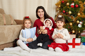 happy family portrait in christmas decoration, winter holiday concept, decorated fir tree and gifts