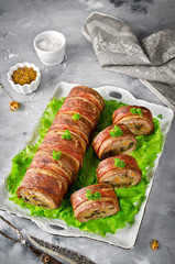 Oven baked meatloaf with bacon on a concrete grey background