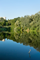 blue lake with trees and building in the distance
